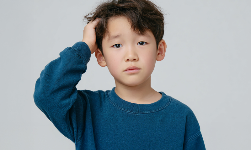 머리를 만지고 있는 어린아이